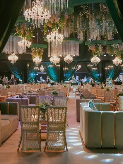Looking out from behind the emerald velvet drapes, this shot captures the vastness of the hall and the layered effect of the hanging chandeliers and ceiling installations.