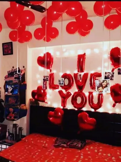 This is a classic romantic room decoration I do for anniversaries and surprises. It includes 'I LOVE YOU' foil balloons, a fairy light backdrop, heart-shaped balloons, and balloons on the ceiling.