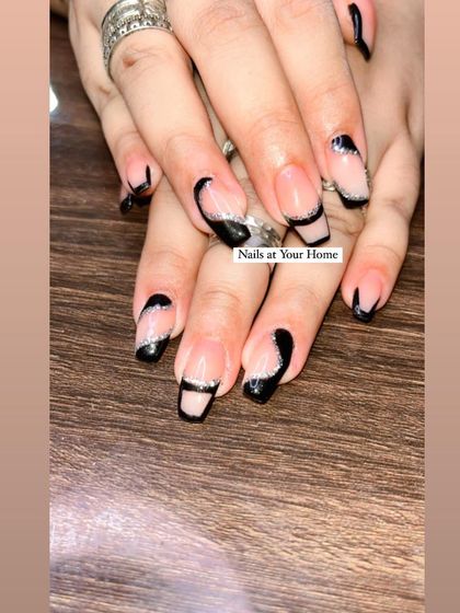 A creative, abstract take on the French manicure with asymmetric black tips and a fine silver glitter accent line.