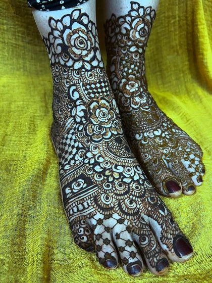 A clear, top-down view of the symmetrical floral foot mehendi. The design is perfectly mirrored on both feet.
