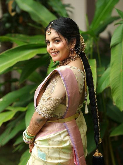 A view from the back, showing the bride's beautiful hairstyle and the keyhole back design of her embroidered blouse.