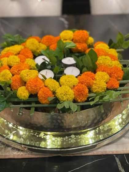 A close-up of my marigold and fairy light urli. The warm glow of the lights intertwined with the flowers creates a magical and festive ambiance, ideal for evening celebrations.