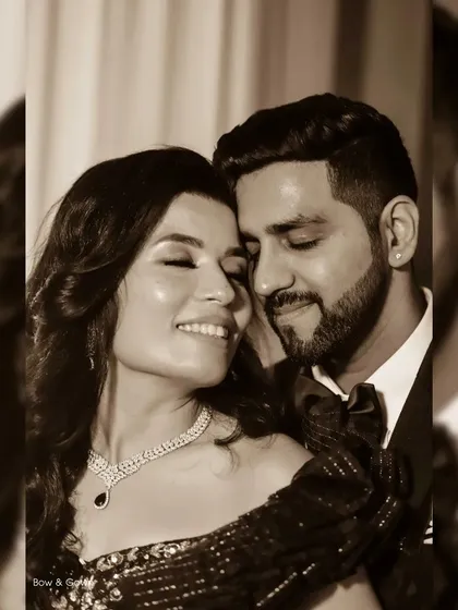A warm, sepia-toned photo capturing an intimate moment between a couple at their reception. This style enhances the romance and emotion, focusing on their close embrace and happy expressions.