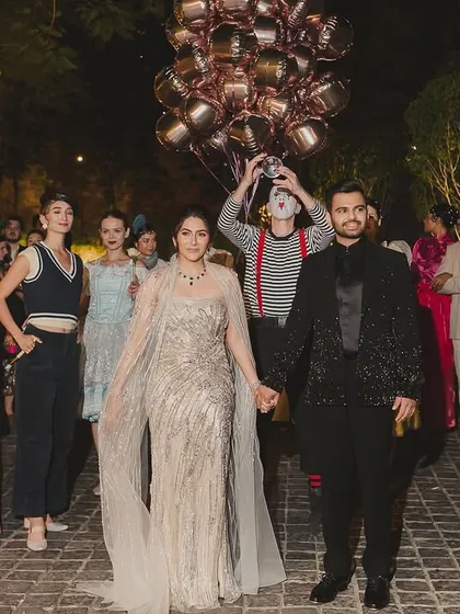 The couple's entry for their Parisian-themed cocktail night was a spectacle in itself, accompanied by mimes, performers, and a balloon-carrying singer to create a whimsical, street-theatre feel.