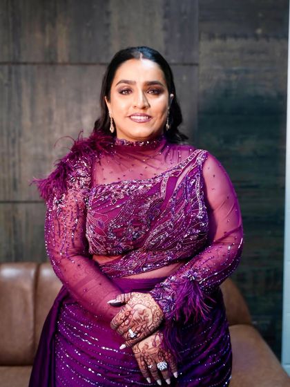 A smiling portrait of this glamorous look. The makeup is bold and confident, perfect for a sangeet or reception.