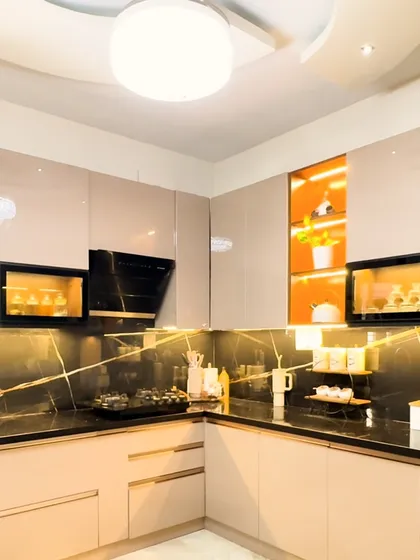 We believe a kitchen should be as beautiful as it is functional. This modular kitchen design features high-gloss laminate cabinets, a striking black marble backsplash, and integrated lighting to create a workspace that is both efficient and inspiring.