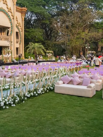 A closer look at the guest seating for the anniversary gala. I used a combination of comfortable sofas with plush cushions for VIP sections and neatly arranged chairs, separated by a floral aisle, to create a luxurious and organized layout.