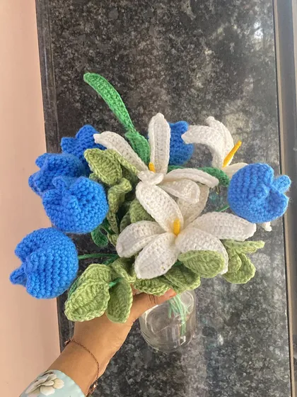 Holding the ocean blue bouquet by a window, the natural light brings out the beautiful textures of the crochet work.