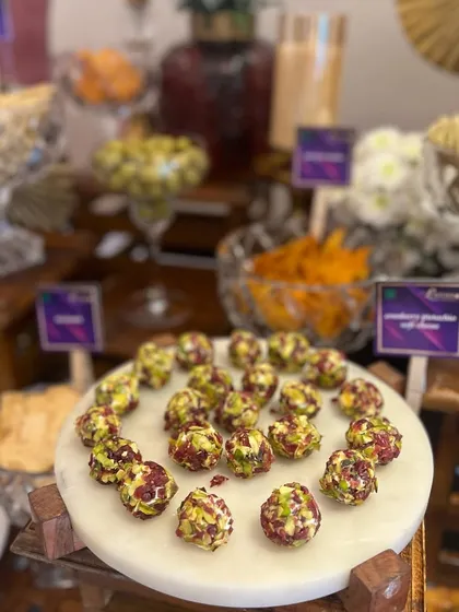 A beautiful marble platter featuring our pistachio and cranberry cheese truffles, a popular choice for cocktail hours and grazing tables.