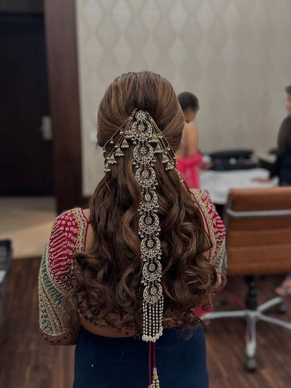 A final look at this stunning half-up style, blending open curls with heavy traditional jewelry.