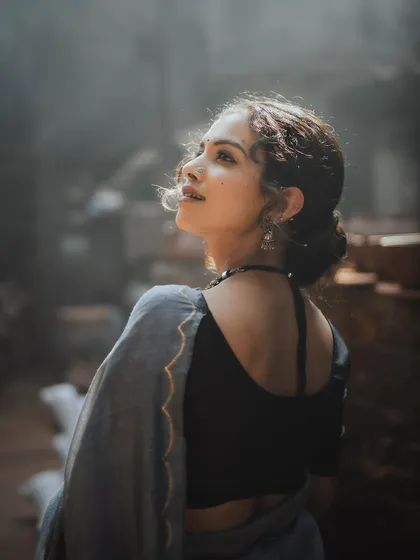 This portrait captures the model looking up towards a light source, creating a hopeful and serene mood. The soft focus on her hair and the back of her saree adds to the dreamy quality.