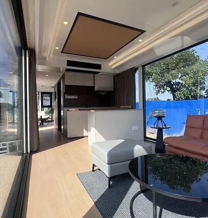 Step inside one of our innovative Space Capsule homes. This interior view shows a fully-equipped, modern living area with large windows that connect you to the outdoors, all within a compact and efficient design.