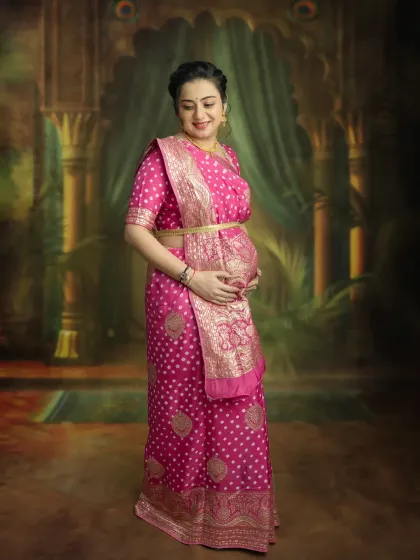 A classic solo maternity pose in a stunning pink saree. This portrait focuses on you and your beautiful bump, creating a simple yet powerful image of motherhood.