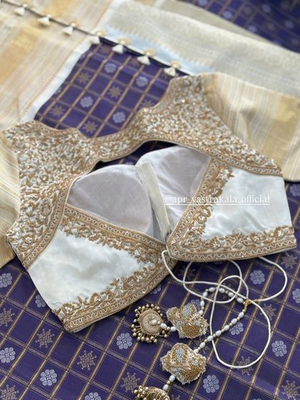 The full layout of the white and gold blouse with matching tassels.