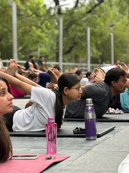 A close-up of participants practicing Salabhasana (Locust Pose) together. You can see the focus and determination on their faces as they strengthen their backs and improve posture.