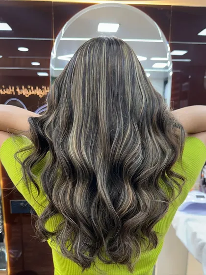 The back view of this ash blonde style, showing how the highlights are woven through the hair for a natural yet impactful look.