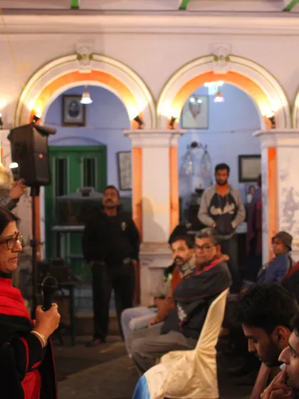 A community discussion taking place in a house courtyard on a winter evening, a simple act of placemaking that brings a space to life.