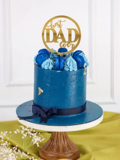 A sophisticated cake for the "Best Dad Ever." This deep blue cake is topped with matching macarons and a stylish gold topper.