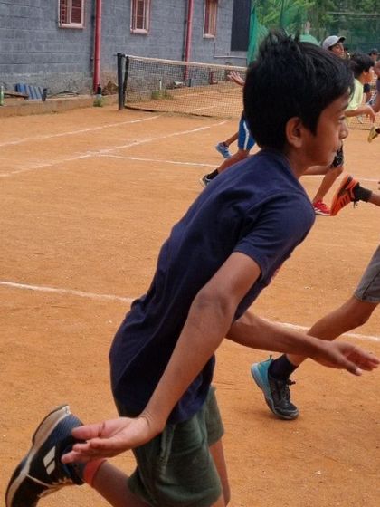 A young athlete mid-stride during a running drill. Proper running mechanics are a fundamental skill for any sport.
