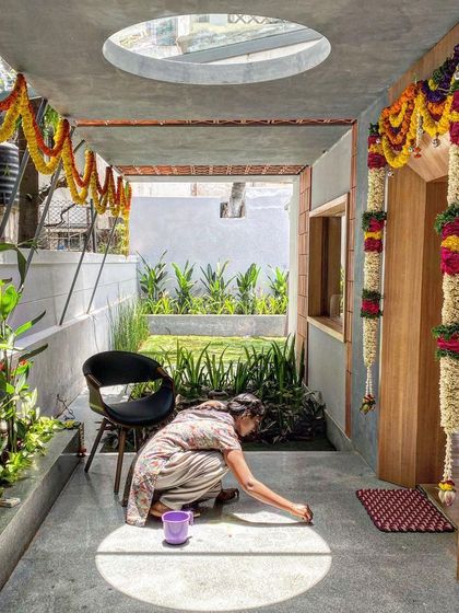 A woman performs a ritual at the entrance of our newly designed office space. The circular skylight casts a perfect spotlight, beautifully merging tradition with modern architecture.