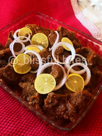 This is my Steak Phaal, an intensely flavorful and spicy Indian-style steak dish. The meat is marinated and cooked in a thick masala until tender, then served with fresh onion rings and lemon wedges to balance the heat.