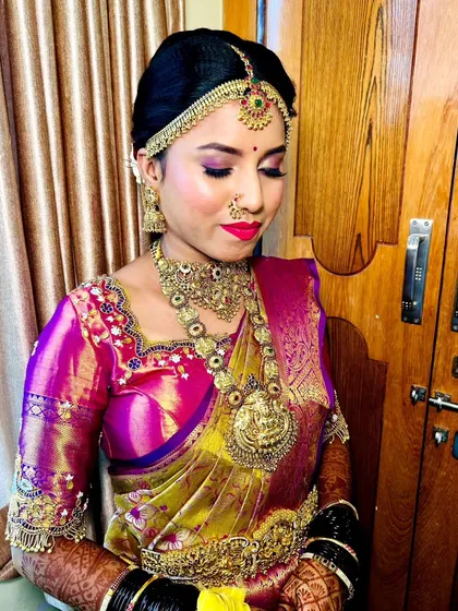 A close-up of a real bride, showing her flawless makeup with closed eyes. The purple and pink eyeshadow is blended beautifully.