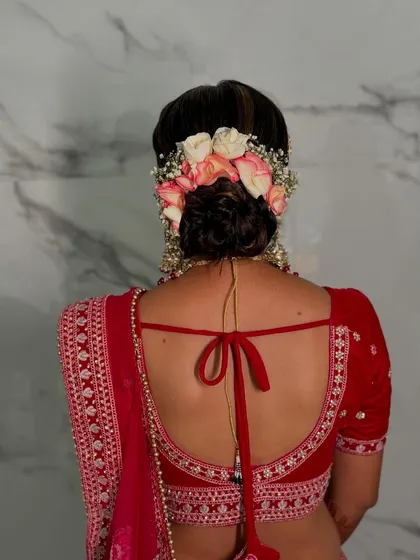 A stunning bridal bun decorated with a crown of fresh pink and white roses and baby's breath. This is the perfect romantic hairstyle for a bride.