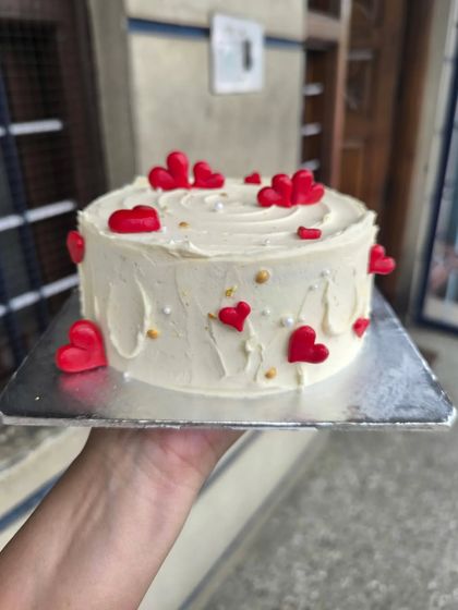 A classic design overflowing with love. This cake is decorated with rustic white frosting and dozens of bright red fondant hearts, perfect for Valentine's Day, an anniversary, or to simply say "I love you."