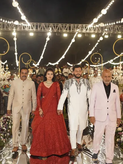 The grand entrance for a truly special couple. We crafted a mesmerizing walkway with a reflective floor that mirrored the hanging chandeliers and string lights above. Lined with lush florals, this path made their entrance feel like a walk amongst the stars.