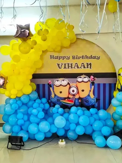 A fun-filled Minions birthday party. This setup uses the signature blue and yellow colors, with a themed backdrop, character foil balloons, and a playful balloon arch.
