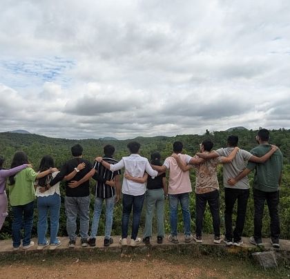 A group of friends enjoying the view from the back, arms around each other. My trips are about building bonds and making connections.