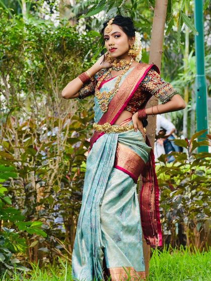 This series showcases a model in a beautiful light blue saree, adorned with a full temple jewellery set. The outdoor setting highlights the richness of the antique gold finish.