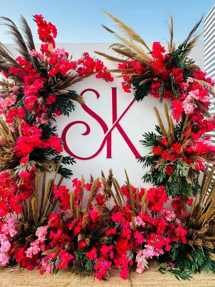 All things pink and pretty for a celebration in Doha. This perfect photo-op features the couple's monogram surrounded by an explosion of vibrant red and pink flowers. 🌺