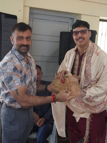 A guru receives a token of appreciation during the Guru Dakshina tradition, a heartfelt gesture of gratitude from the students and the institution.