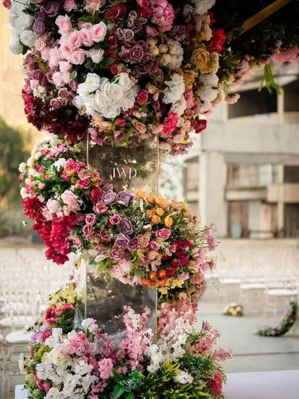 Detail of the floral spiral on the pillar of the upside down garden mandap. This shows the intricate craftsmanship involved in weaving countless flowers into a seamless, artistic structure for a luxury wedding.
