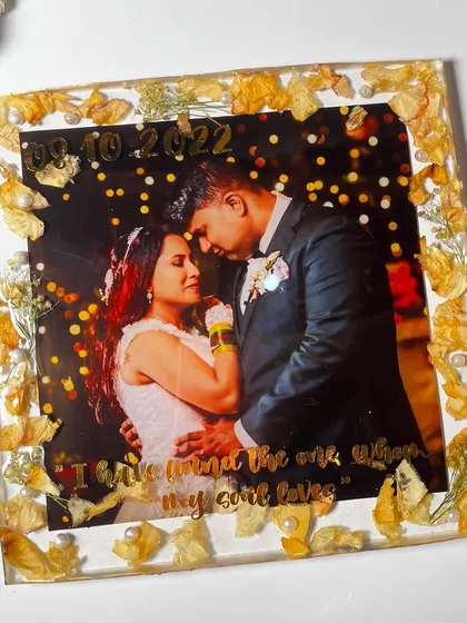 This 10-inch frame beautifully preserves a couple's engagement memories. The delicate white flowers are arranged around their photo, creating a simple yet elegant piece.