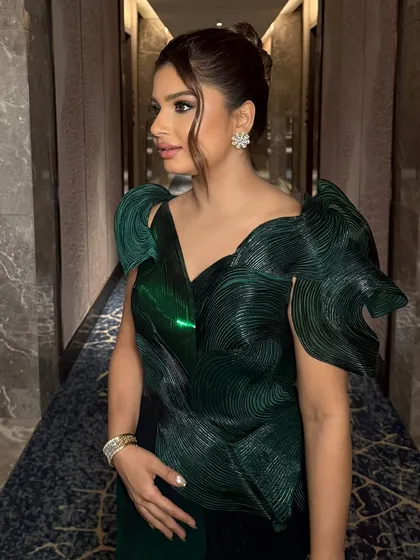 A side profile of Riddhi's metallic glam look. The green chrome eye makeup is a bold and beautiful choice for an evening event.