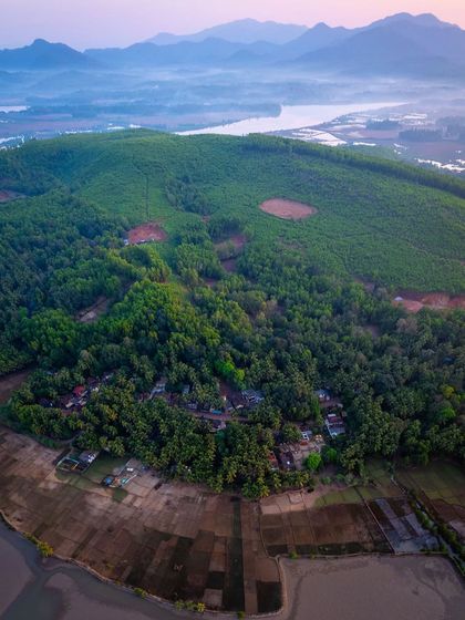 The fertile banks of the Aghanashini River in Uttara Kannada, a lifeline for the region. From above, you can see the intricate network of the river, mangrove forests, and agricultural lands that it supports.