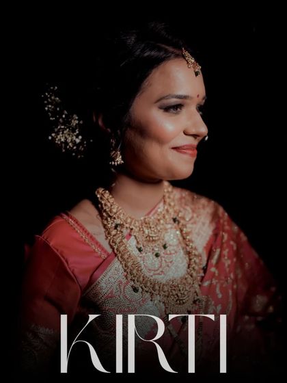 A stunning portrait of the bride, Kirti, at her reception. The dramatic lighting highlights her elegant saree, intricate jewelry, and radiant smile.