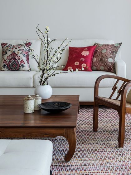 We often use textiles to introduce color and pattern. In the Terrazzo Residence, these vibrant, Indian-inspired cushions add a splash of personality to a clean, white sofa, perfectly complementing the rich tones of the teak coffee table.