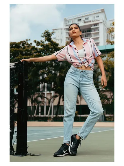 An on-location shoot that blends fashion with a casual, urban environment. The natural light and relaxed pose create an authentic, lifestyle-oriented portrait that feels both stylish and approachable.