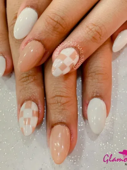 A chic and modern design featuring a mix of solid nude and white nails, with accent nails showcasing a trendy checkerboard pattern.
