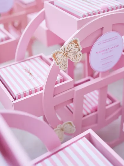 A closer look at the details of our bespoke baby announcement gifts. The delicate butterfly accent adds a touch of whimsy to these custom pink rocking horse boxes.