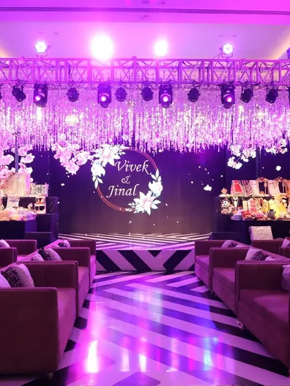 The stage for this Sangeet was all about glamour, with a massive crystal chandelier installation, a striped floor, and dramatic purple lighting creating a high-impact look.