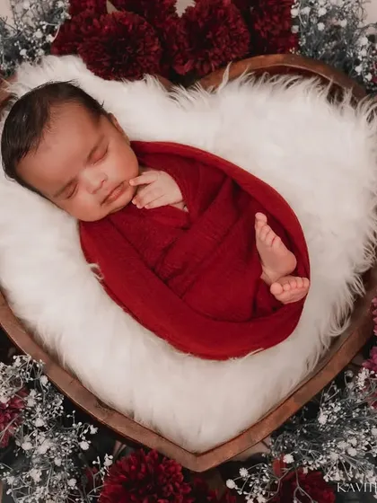 I believe every newborn is a tiny miracle. For this newborn portrait, we used a heart-shaped basket and rich, deep red tones to create a warm, love-filled setting that feels as precious as the baby sleeping inside.