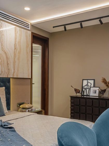 The master bedroom's layout includes a dark wood credenza and a fluted glass door leading to the walk-in closet. The material and color palette of beige, brown, and teal creates a cohesive and serene retreat.