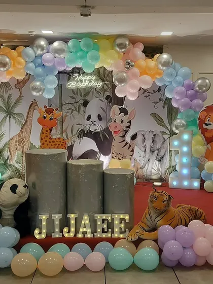 A complete jungle-themed setup for a first birthday party. We used a custom backdrop, life-sized cutouts of safari animals like a panda, tiger, and giraffe, and a pastel-colored balloon arch to create a fun and immersive environment for the little one.