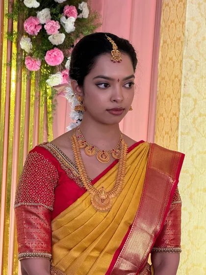 A side profile of Dr. Sushmita, showing her elegant and understated Muhurtham look. The focus is on clean skin and softly defined features, embodying a timeless bridal aesthetic.