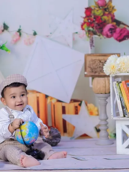 This little explorer is playing with a globe, ready to discover the world. A great shot for a curious and adventurous one-year-old.