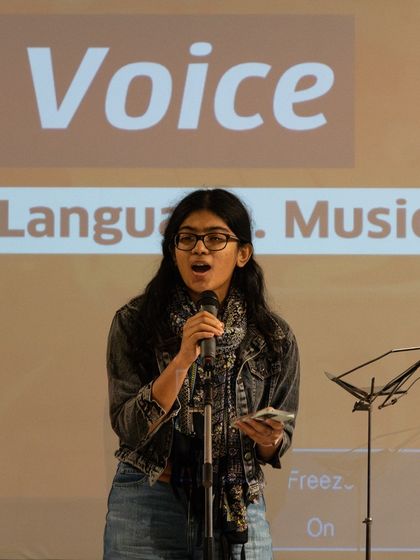 A participant delivering a confident performance after our two-week workshop. The growth in our students' stage presence is incredibly rewarding to witness.